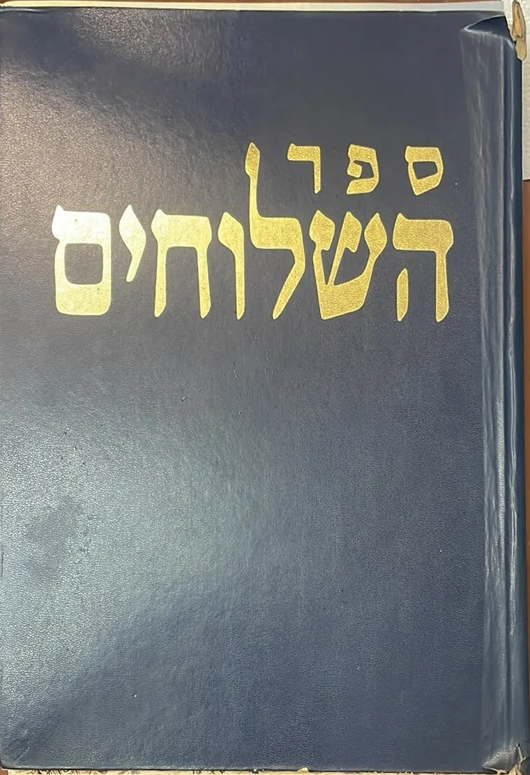 כריכה כחולה ובלויה של ספר, ועליה באותיות זהב: ספר השלוחים.